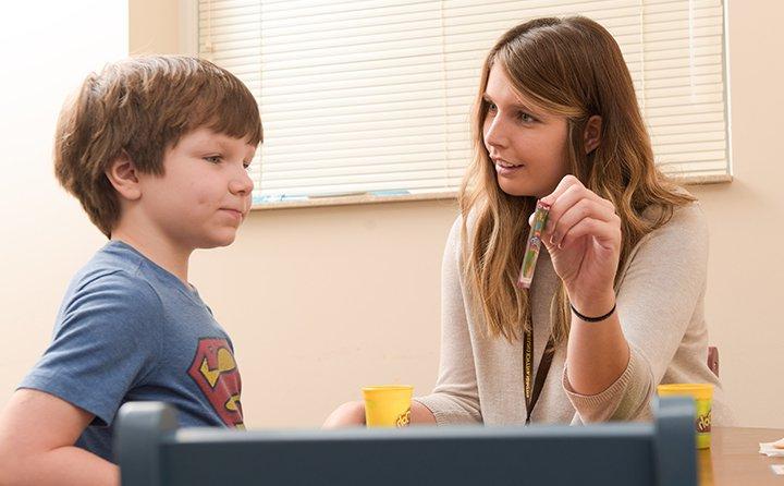 A student working with a boy in the BW Speech Clinic. 